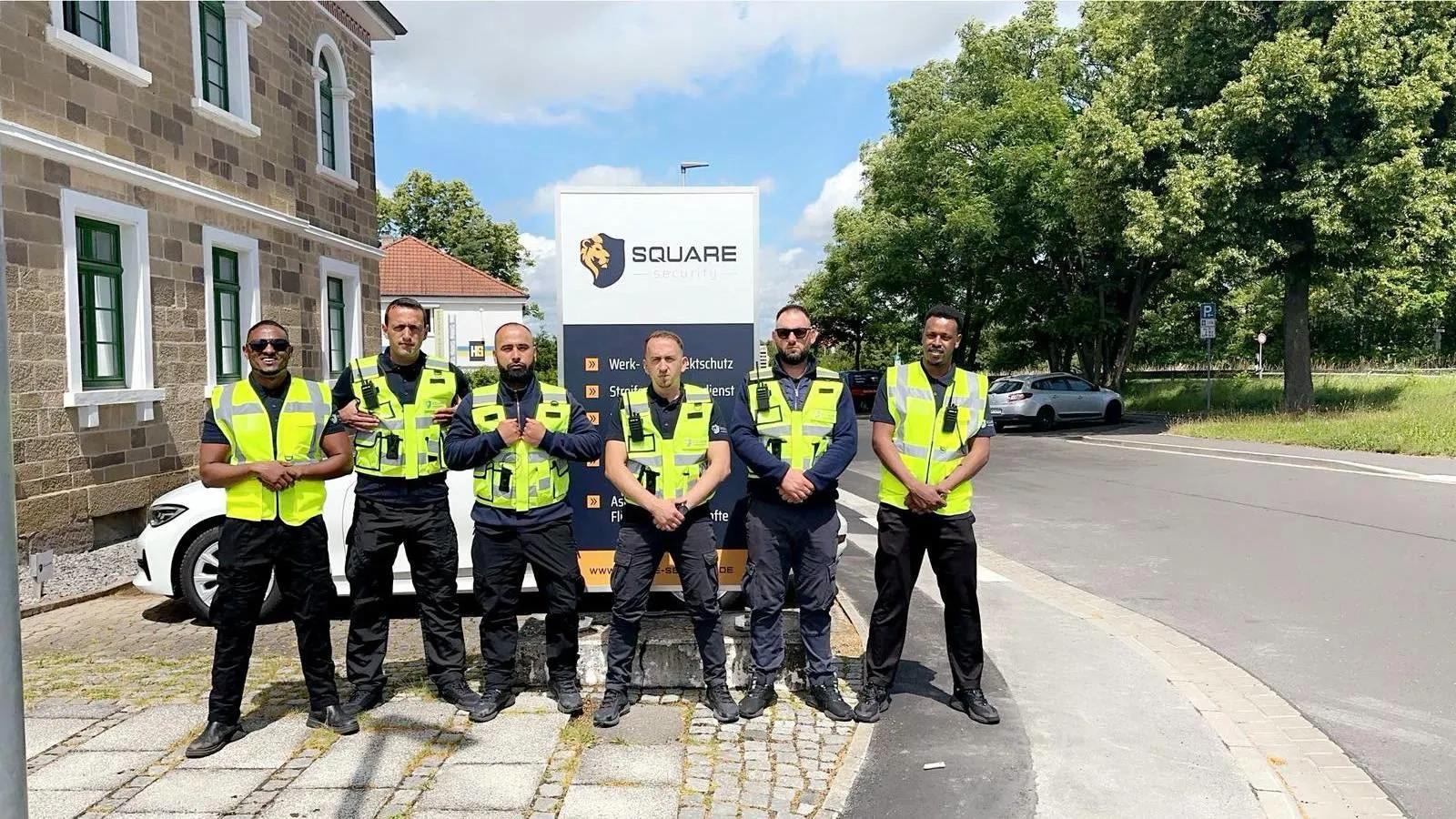 The Square Security team in high-visibility vests in front of the company sign
